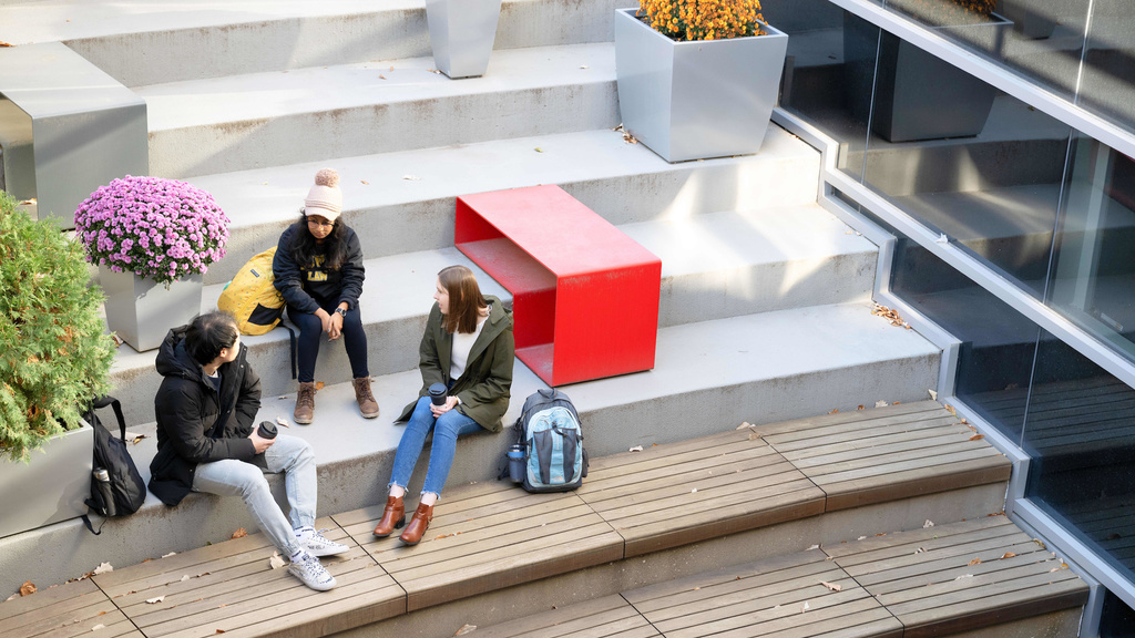 Aerial view of students sit in the Seldin Portico during fall.
