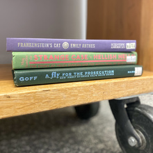 Stack of books in the law library, including: Frankenstein's Cat, the Strange Case of Hellish Nell, and a Fly for the Prosecution  
