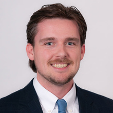 Alexander Hook, smiling against a white backdrop.