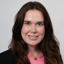 Maura McNamara, smiling against a white backdrop.
