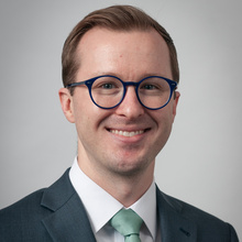 Sean McQuade, smiling for a headshot against a white backdrop.