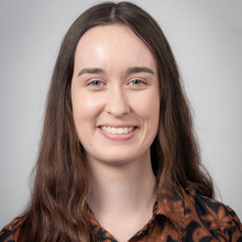 Karlyn Simcox, smiling for a headshot against a white backdrop.