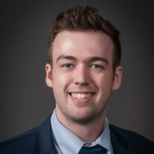 Andrew Jackson posing for a professional headshot against a dark backdrop.