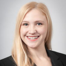 Dana Haverkamp smiles for a professional photo against a light gray backdrop.