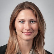 Nina Marquardt Westphal smiles for a professional photo against a light gray backdrop.