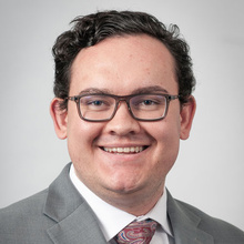 Rory Mosley smiles for a professional photo against a light gray backdrop.