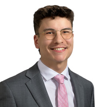 Nickolaus Cabrera, smiling for a professional photo against a white backdrop.