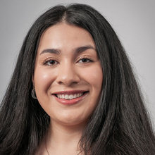 Liz Vargas-Perez smiles for a professional photo against a light gray backdrop.