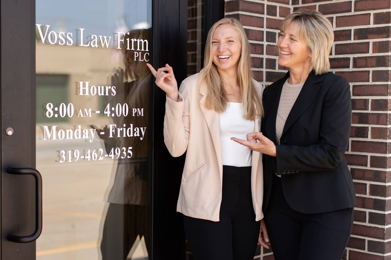 JoAnna and Janette Voss stand in front of the door to Voss Law Firm, PLC.