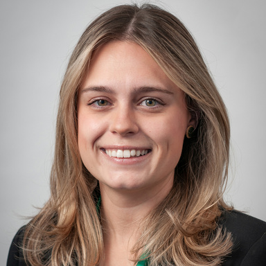 Lauren Keating, smiling for a headshot against a white backdrop.