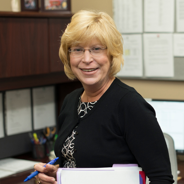 Jan Barnes, smiling in the admissions office
