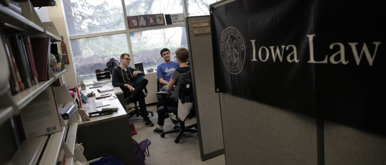 Members of Iowa Law Review sitting at desk in Boyd Law Building 