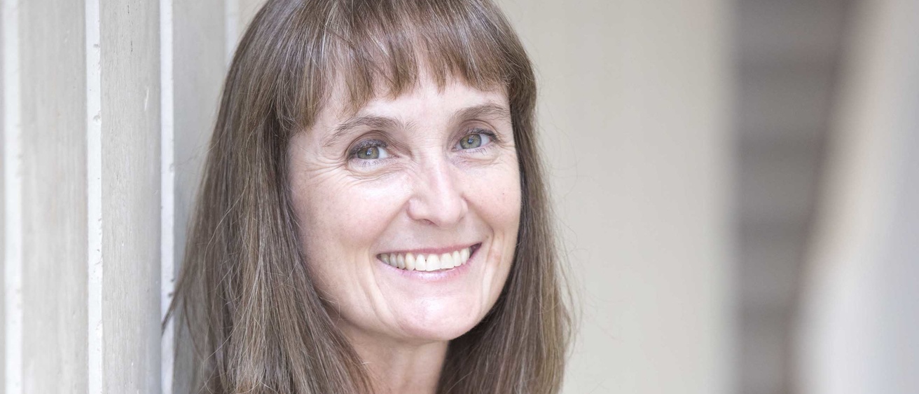 Professor Emily Hughes standing against a white wall