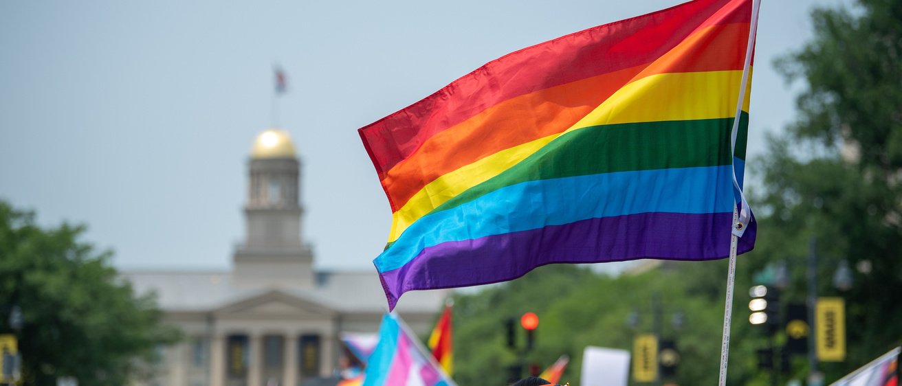 Pride flag waves at Pride Parade in front of the Old Capitol Building in Iowa City 2023