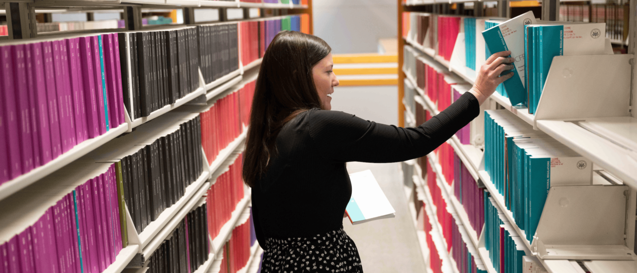 Librarian Amy Koopmann pulls a book from the stacks at the UI Law Library.
