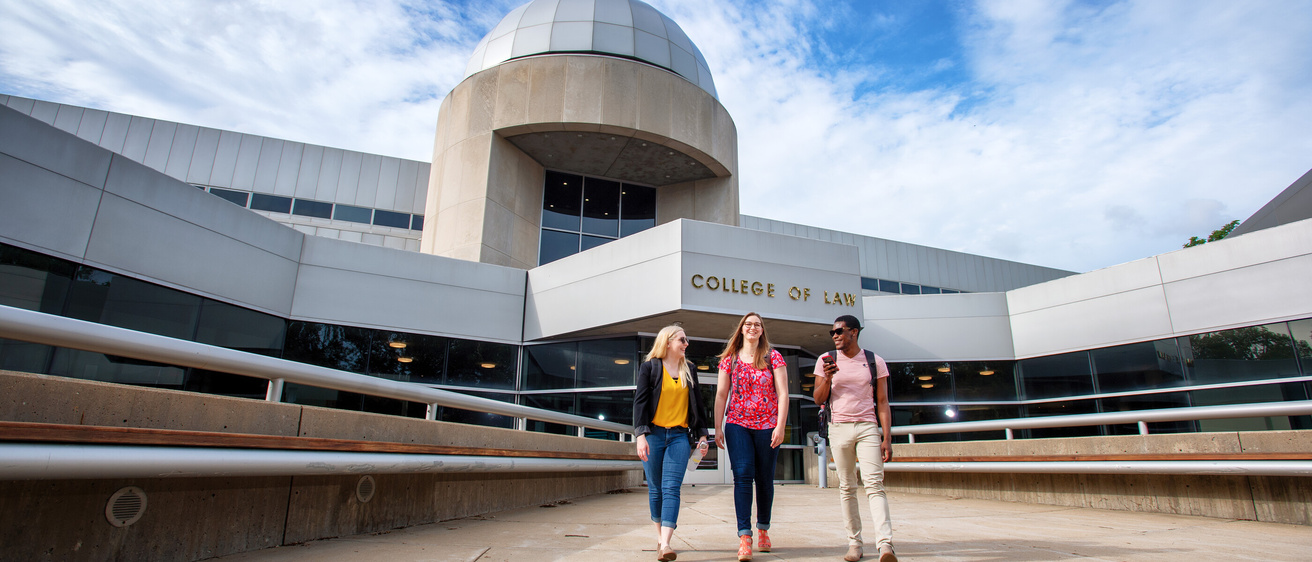 Three students walking out of the Boyd Law Building.