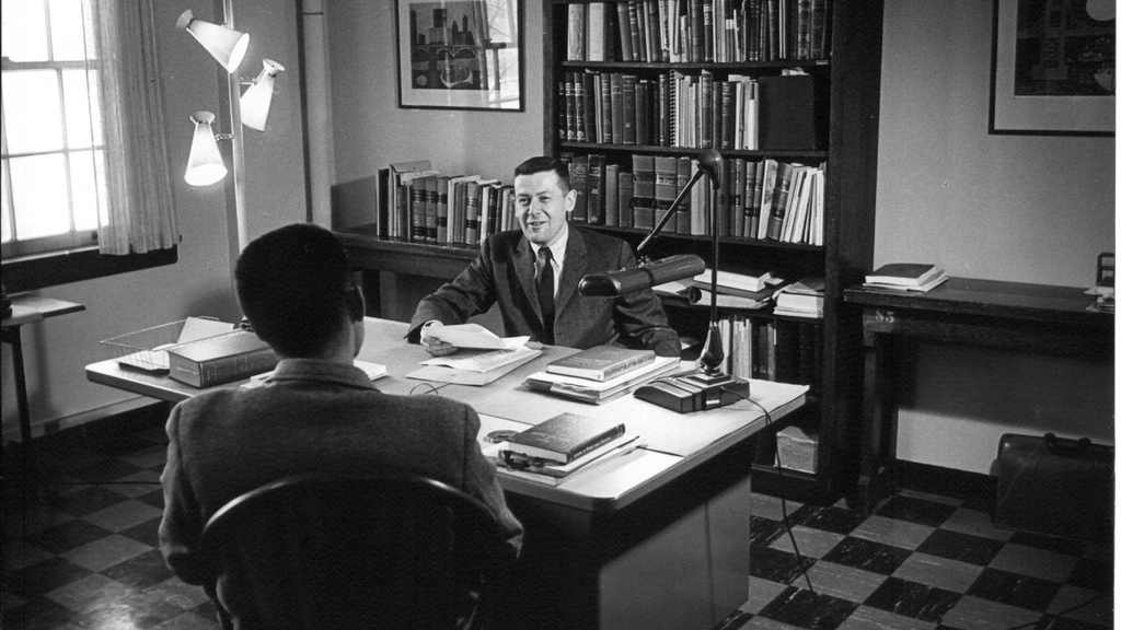 Sandy Boyd sitting at a desk in the 1950s in a black and white photo.