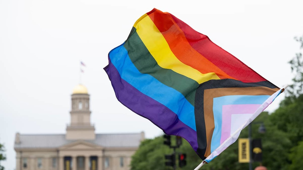 Pride flag waves at Pride Parade in front of the Old Capitol Building in Iowa City 2024