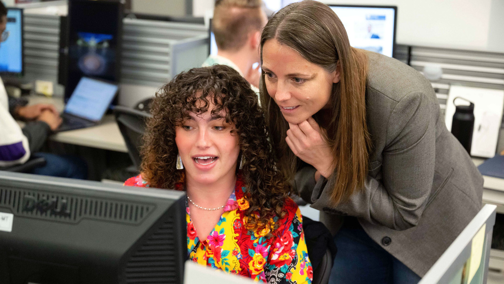 Professor Alison Guernsey, assisting a clinic student at her computer.